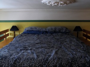 Double bed mattress on raised platform, in lounge. Please note that walls are now painted all-white.